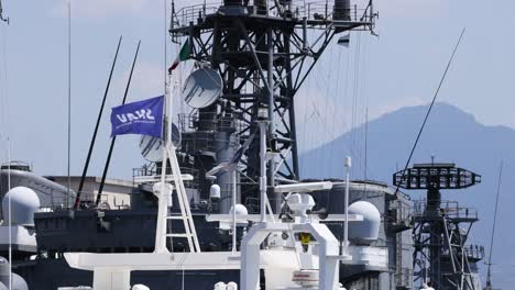 battleship with waving flag in naples, italy