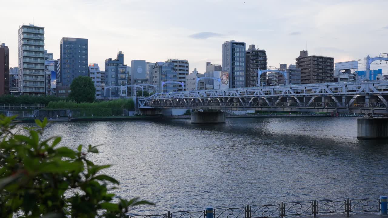 A shot capturing the dusk urban scenery of the Sumida River, including its bridges, sluice gates, and Tokyo Mizumachi along the Kita-jūkken-gawa River