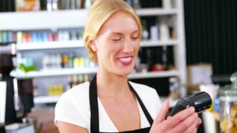 Smiling-waitress-holding-payment-terminal-machine