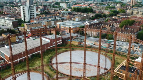 Rostiger-Viktorianischer-Gasbehälter-In-Ostlondon-Mit-Drohne,-Die-Die-Lokale-Grüne-Skyline-Von-Bethnal-Mit-Wohngebäuden-Enthüllen