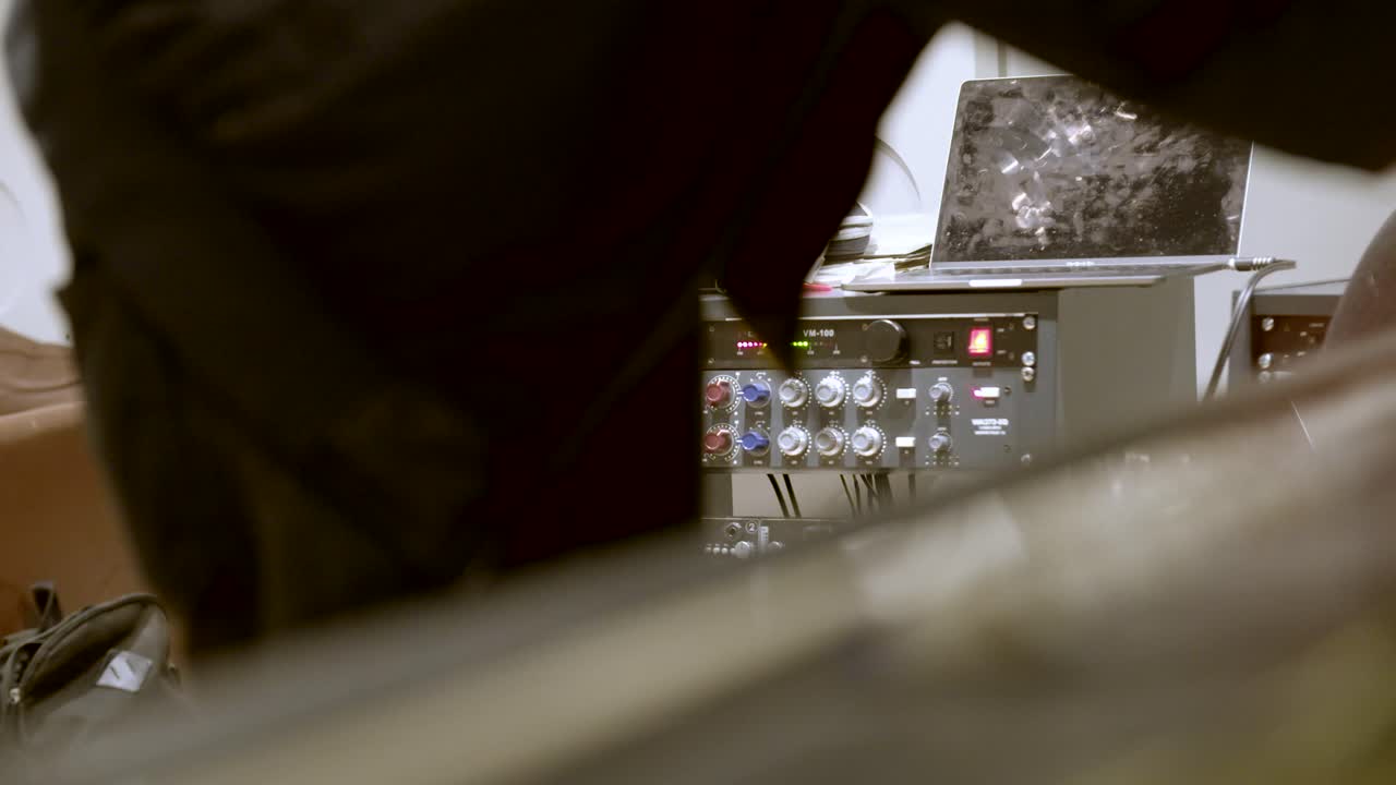 Studio di registrazione - Ingegnere che collega cavi su un banco di missaggio - messa a fuoco su apparecchiature esterne