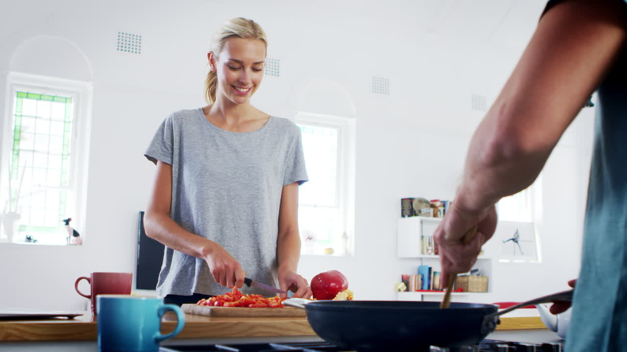 una joven pareja preparando comida juntos en una cocina moderna