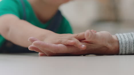 primer plano niño pequeño sosteniendo la mano de la abuela mostrando afecto niño amoroso mostrando compasión por la abuela disfrutando de la vinculación con el nieto concepto de familia 4k metraje