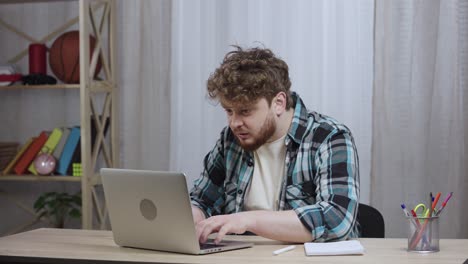 hombre trabajando en una computadora portátil en casa