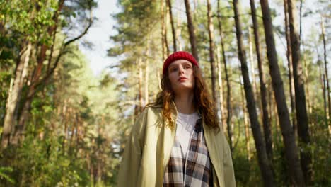 woman in a red hat walking through a forest