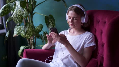 young girl texting while listening music in headphones