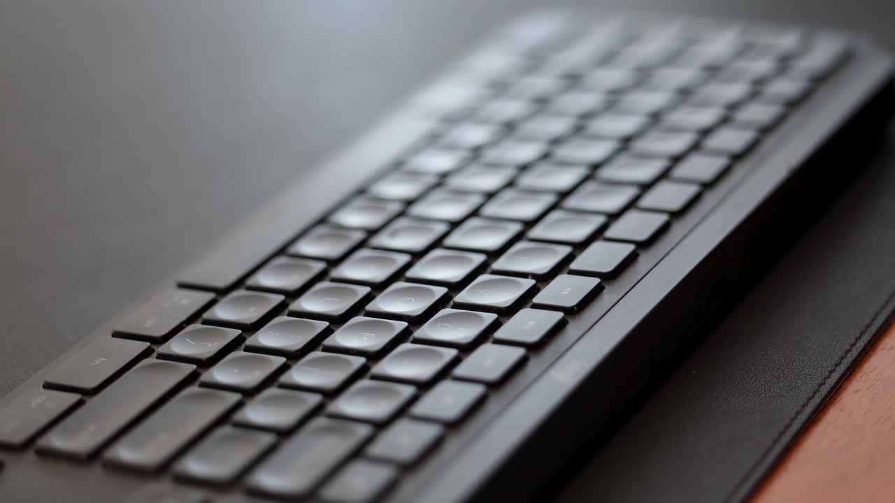 Cinematic pan of a keyboard with shallow depth of field in a professional workspace