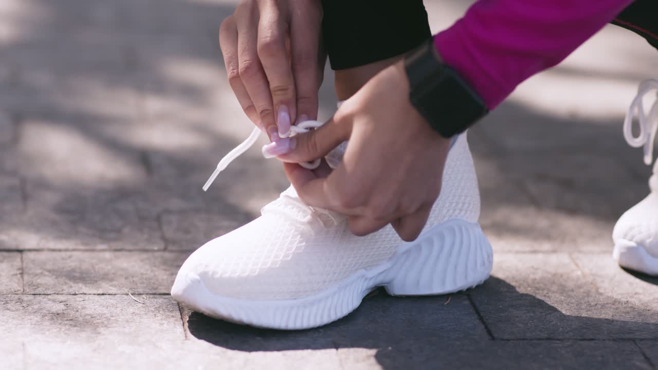 mujer atando sus zapatillas de correr