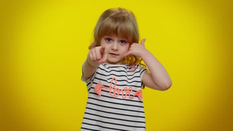 Little-cute-blonde-child-girl-looking-at-camera-doing-phone-gesture-like-says-hey-you-call-me-back