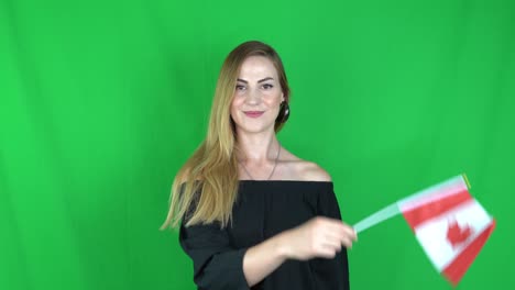 young blonde woman waving in front of canada flag green screen, chroma key background - canada flag stock video clip footag