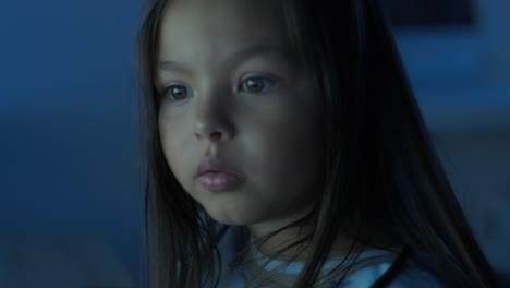 a young girl sits in front of a computer, displaying strong emotions. the scene captures her expressive reaction during an engaging moment, set in a cozy indoor environment