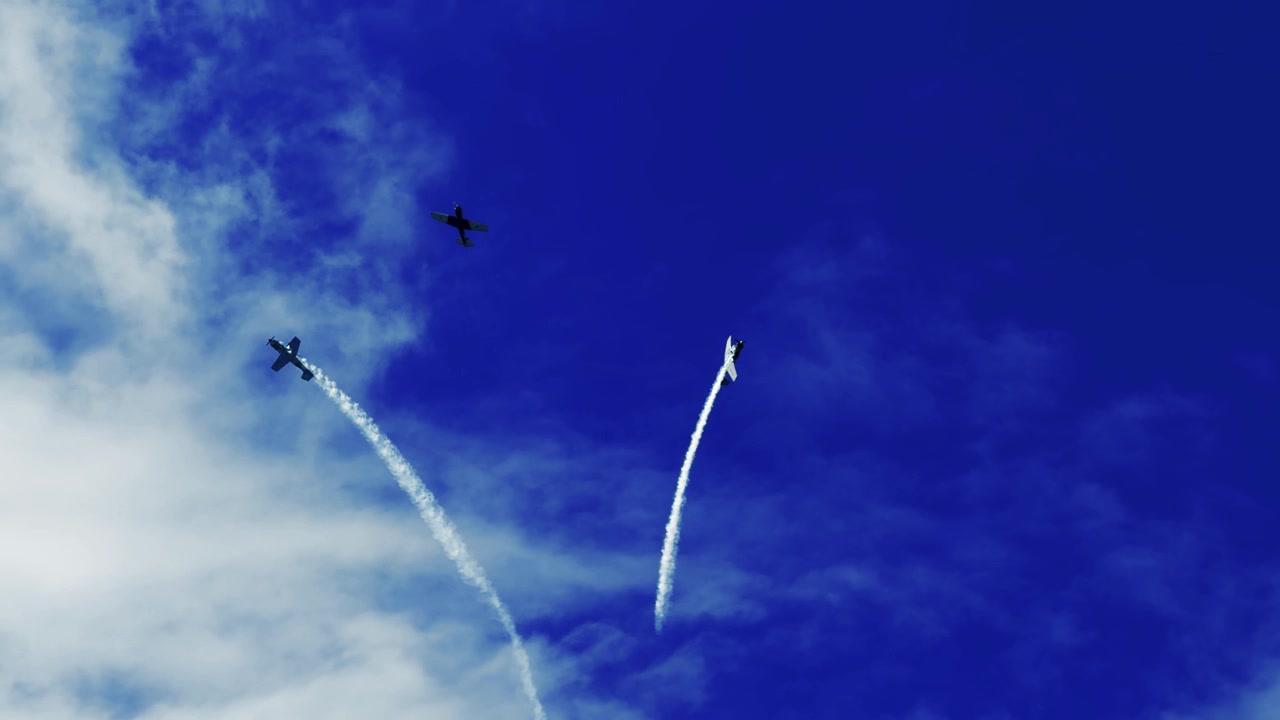 Propeller aircraft perform precision maneuvers with smoke trails against a blue sky in Australia.