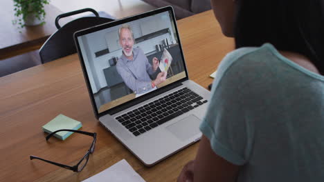 mujer afroamericana haciendo una videollamada con un colega masculino en una computadora portátil