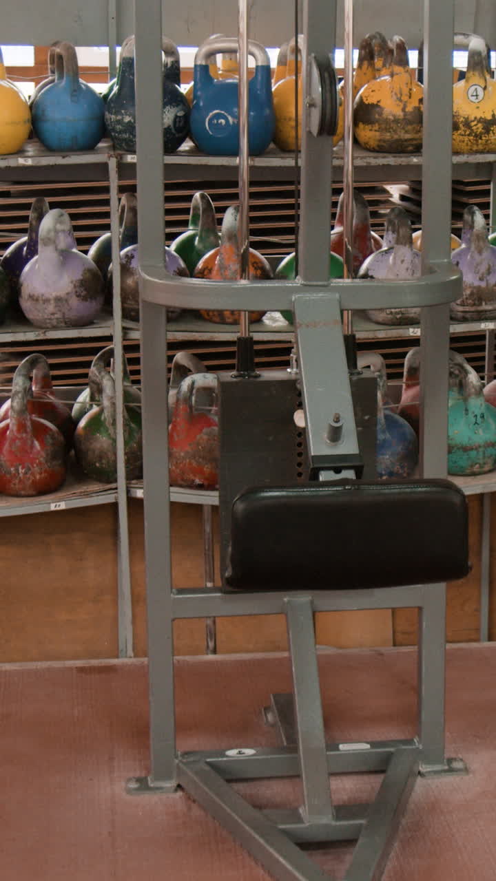 Gym interior with rows of kettlebells and exercise equipment