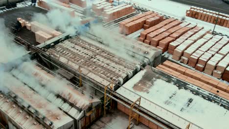 overhead shot of industrial dry kilns and large stacks of plywood on sawmill production site in canada