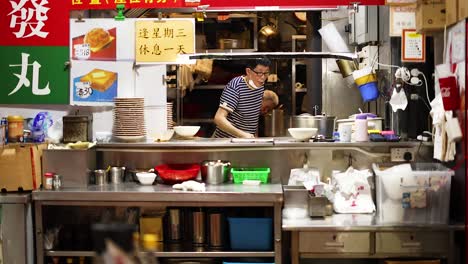 chef prepares food at bustling street stall