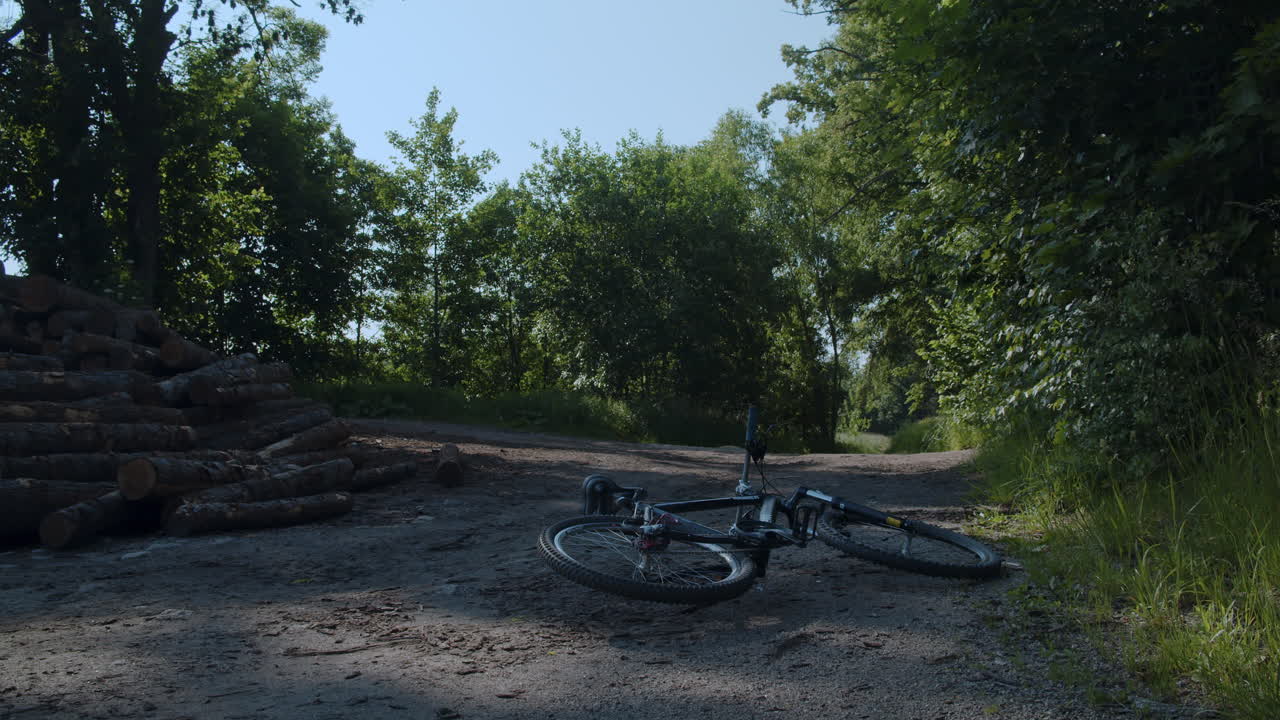 Bike on remote dirt road near abandoned forest path and tree logs