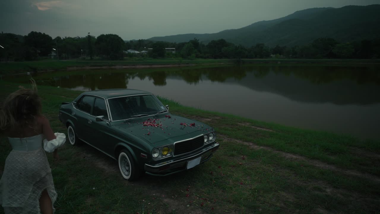 Woman near a vintage car by a lake