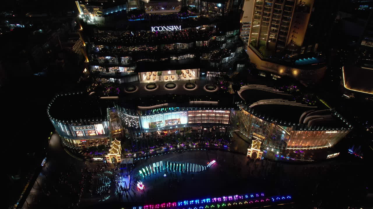 Aerial view rising away from the colorful ICONSIAM mall, evening in Bangkok