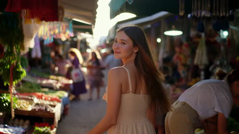 woman walking and smiling in a vibrant outdoor market