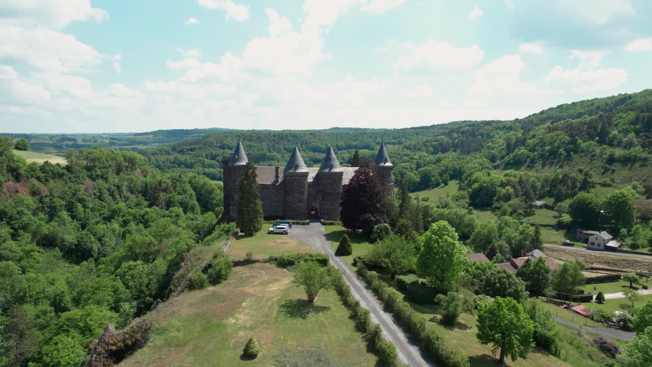 Aerial shot approaching Sailhant Castle during a nice summer day in the city of Andelat, Cantal departement, Auvergne Rhone Alpes region, France