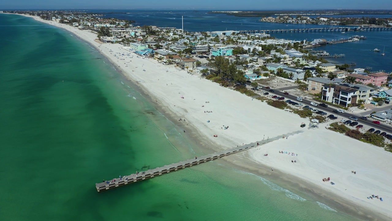 Aerial view capturing the expansive white sands and vibrant green waters of Bradenton Beach.