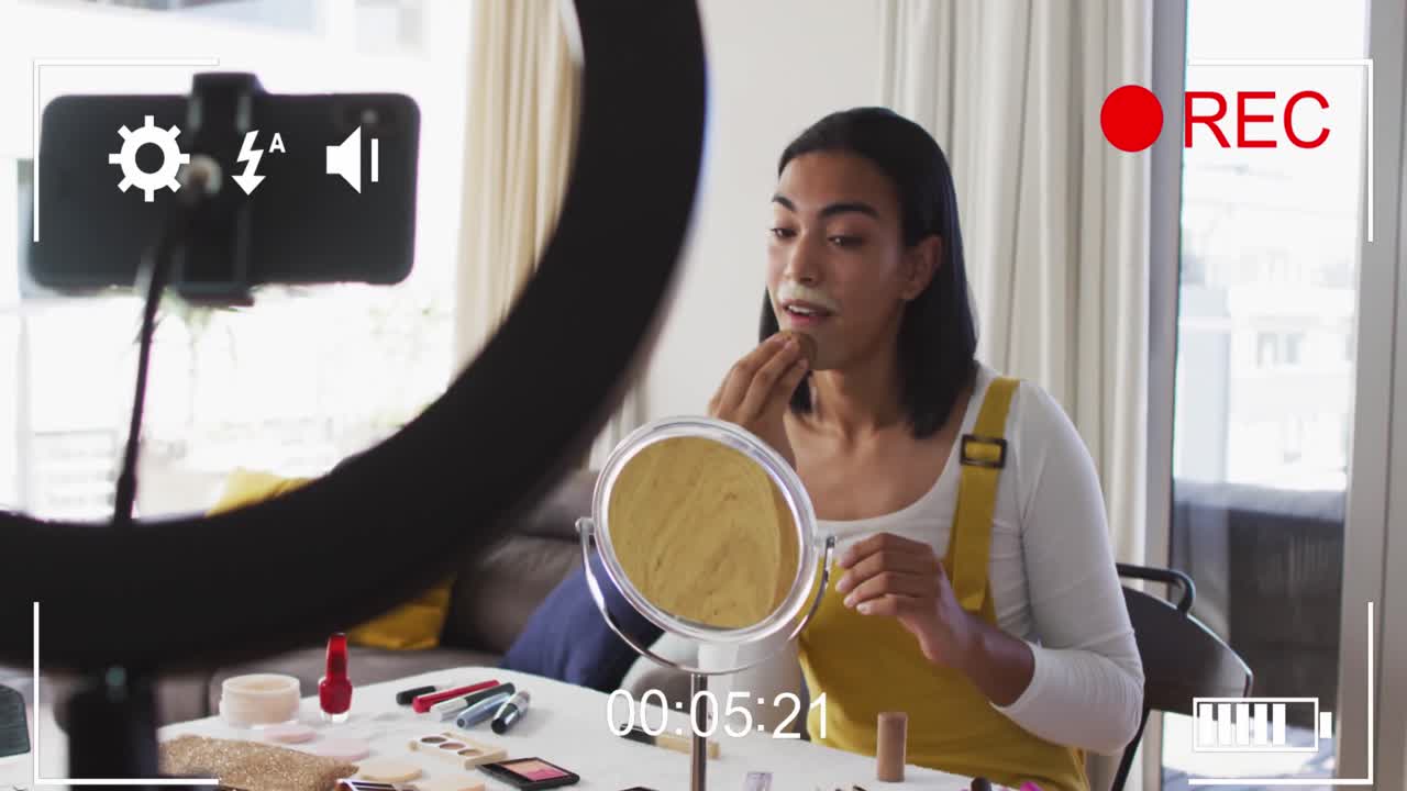 animación de la interfaz digital y los iconos sobre la mujer biracial en el vlog de maquillaje.