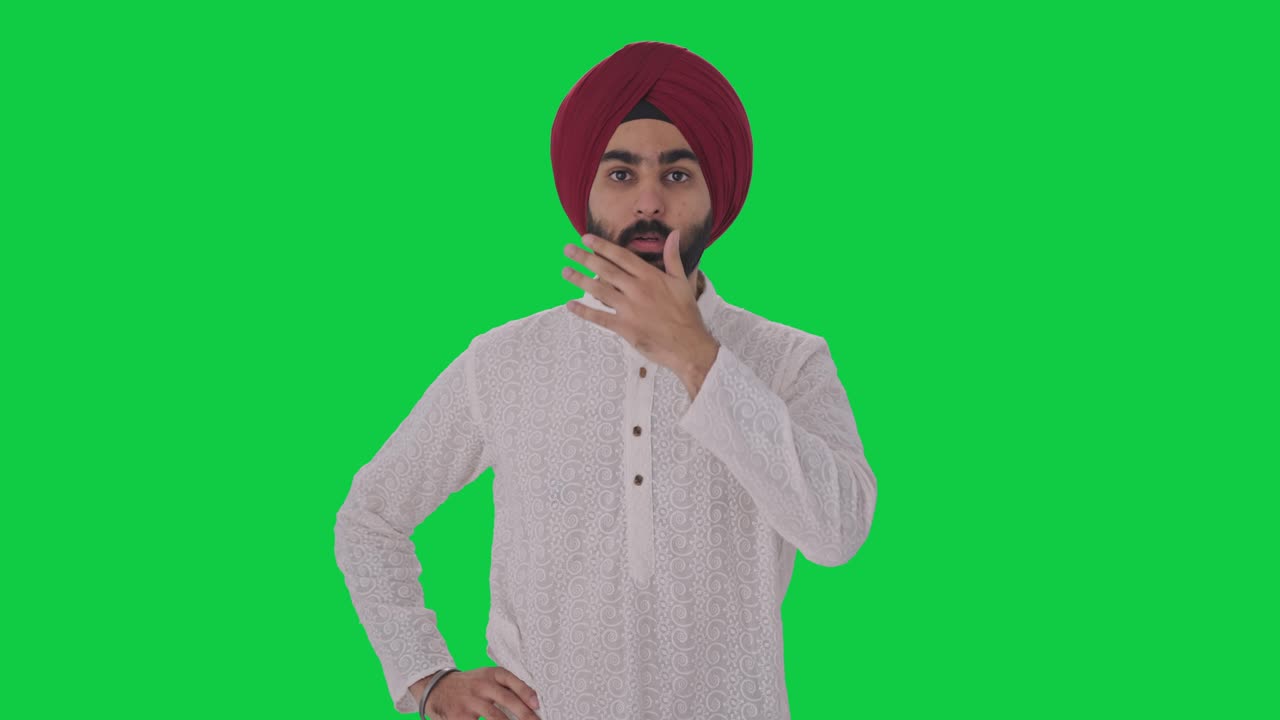 un hombre indio sikh molesto recibe una pantalla verde de noticias chocantes