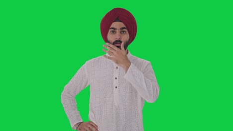 un hombre indio sikh molesto recibe una pantalla verde de noticias chocantes