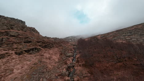 Remote mountain ridge landscape shot with FPV drone on a misty spring morning