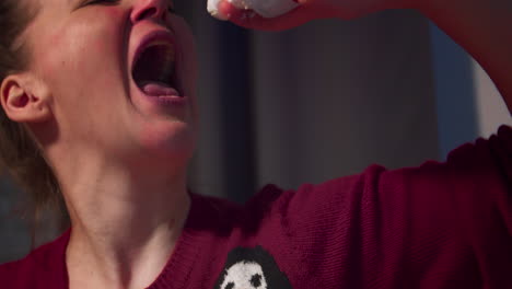 woman spraying whipped cream into her mouth