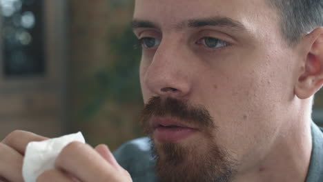 man crying and wiping tears in therapy session