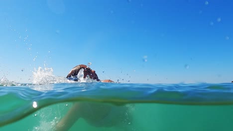 Vista-Medio-Subacuática-De-Una-Niña-Pequeña-Aprendiendo-A-Nadar
