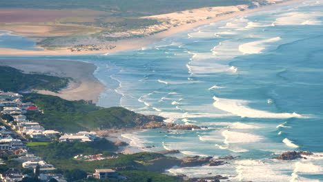 high angle telephoto view over hermanus beaches at voëlklip with crashing waves