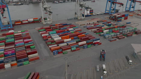 Forklifts-and-colorful-cargo-containers-in-industrial-shipping-port-in-Hamburg,-Germany