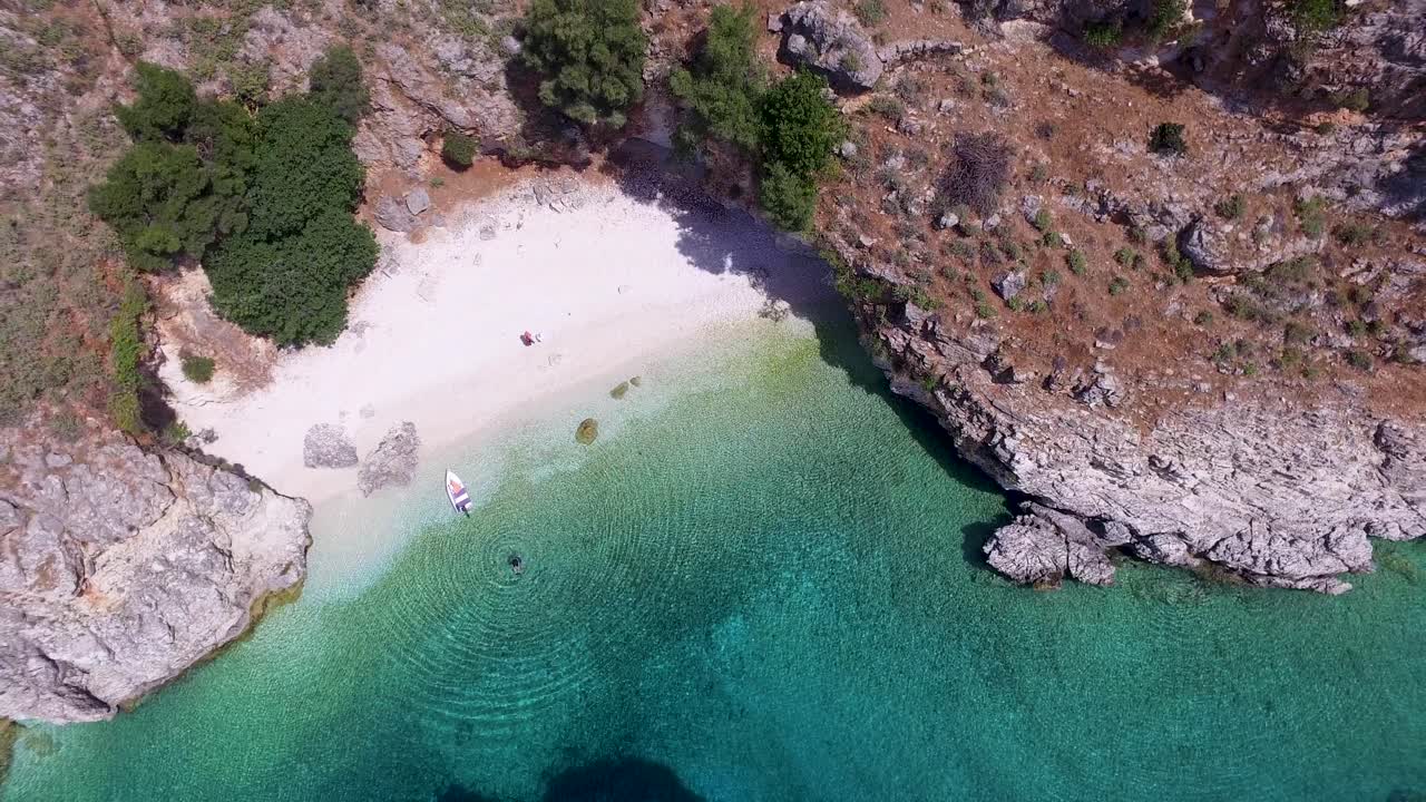 Retreating overhead drone shot of Agriosiko Beach, a secret getaway in Cephalonia, off the coast of Greece in the Ionian islands