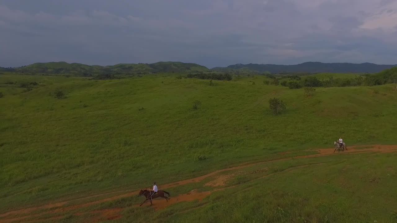 Due Cavalieri Galoppano I Loro Cavalli Su Una Strada Di Terra Rossa In Una Pianura Venezuelana, Rallentatore