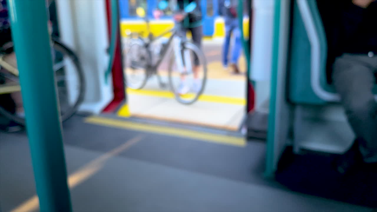 Man Exits Red Train Doors and a Woman Enters with a Bicycle, out of focus in Slow Motion