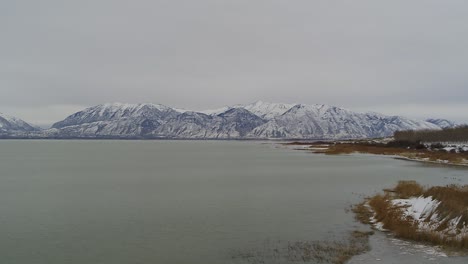 aerial drone shots of the south end of utah lake in the winter, looking toward the mountains