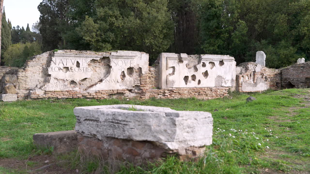 Remains of ancient inscribed wall at entrance to historic Roman port city of Ostia Antica
