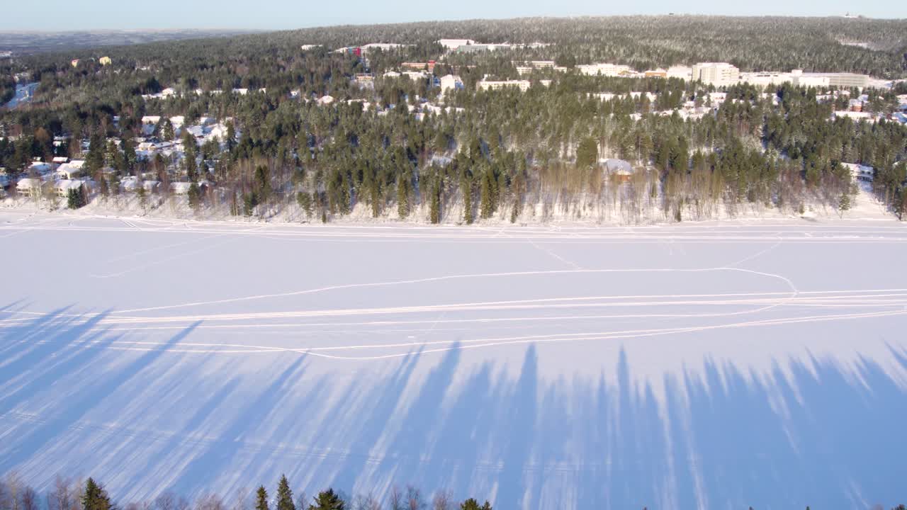 Aerial View of a Frozen Lake and Snowy Village in Winter
