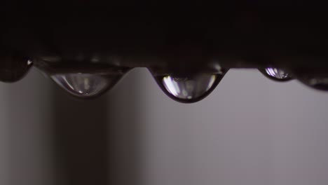 gota de agua que se escapa de la tubería de metal de plomería, primer plano extremo