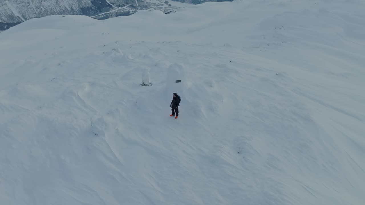 esquiador solo en la cima de la cumbre finnbunuten en el paisaje cubierto de nieve myrkdalen noruega - antena girando sobre el hombre mientras cambia la altitud y el fondo