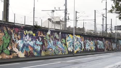 graffiti-covered wall along a city street