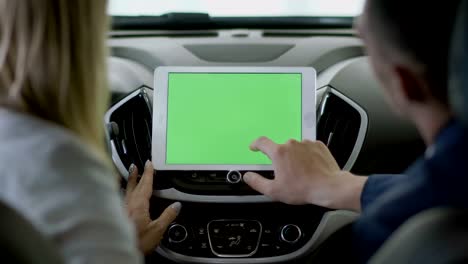 el gerente muestra la información en la tableta a la mujer dentro del coche