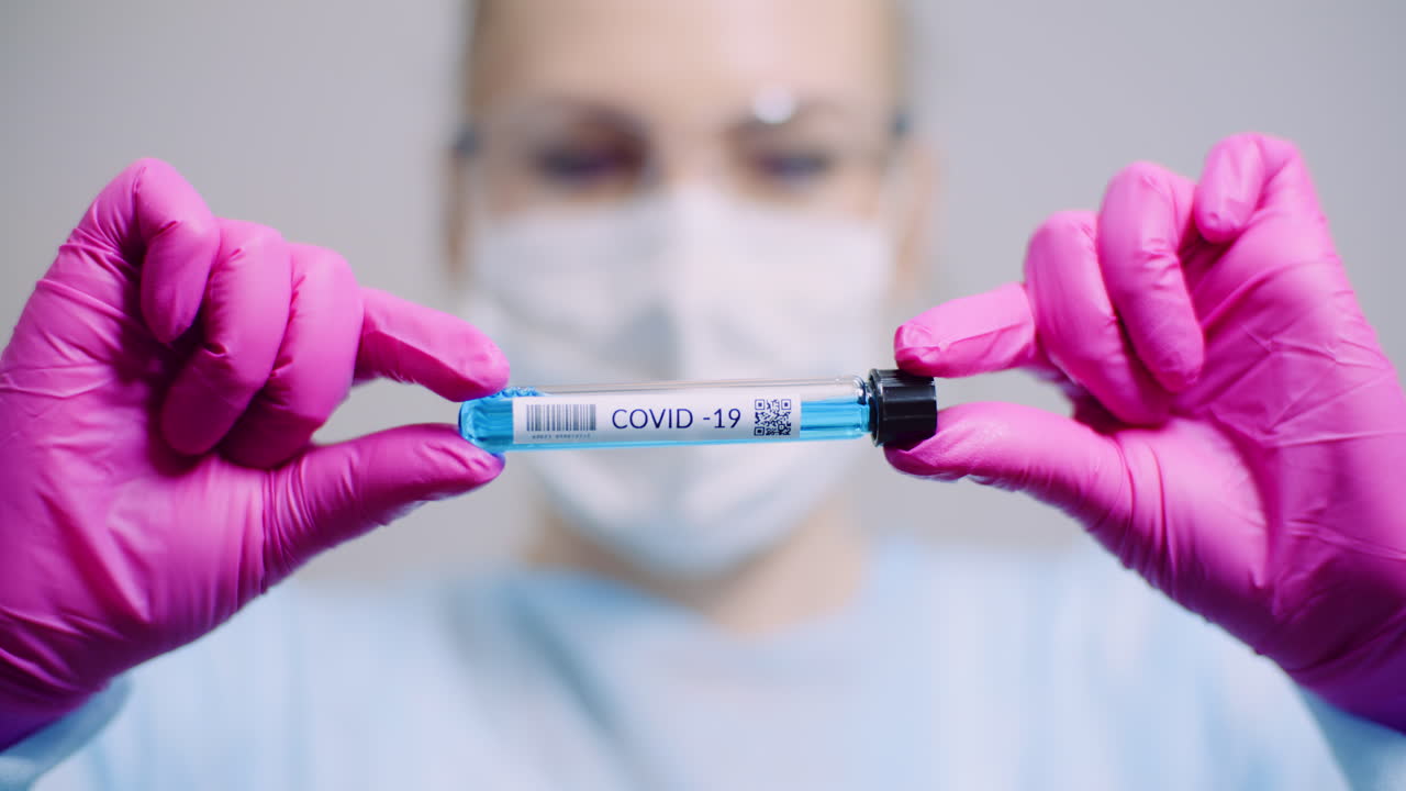 trabajando en un científico de laboratorio que sostiene tubos de ensayo con prueba positiva de covid 19 coronavirus en el laboratorio 1