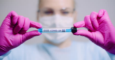 working in lab scientist holding test tubes positive test of covid 19 coronavirus at laboratory 1