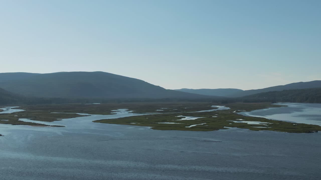 Fredelig landskap ved Saint Lawrence-elven i Quebec, Canada med tåkete fjell i bakgrunnen – langsom panorering