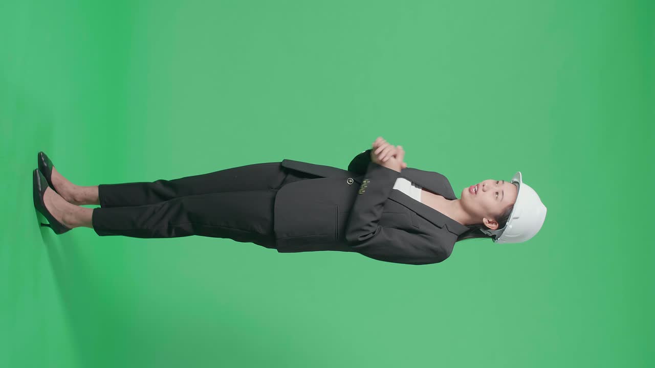 Full Body Of Side View Of Smiling Asian Female Engineer Talking In The Green Screen Studio