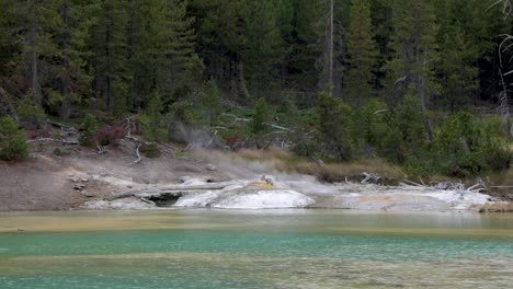 Dampf-Steigt-Aus-Dem-Knisternden-See-Mit-Kristallklarem,-Blauem-Wasser-Auf,-Der-Im-Norris-Geysir-Becken-Im-Yellowstone-Nationalpark,-Wyoming,-Fließt-–-Weitwinkelaufnahme